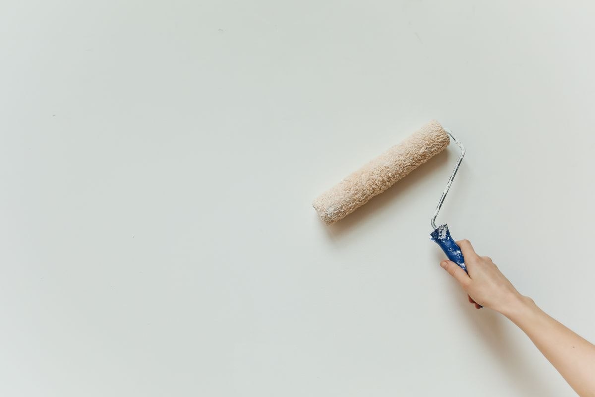 Paint roller on a white interior wall